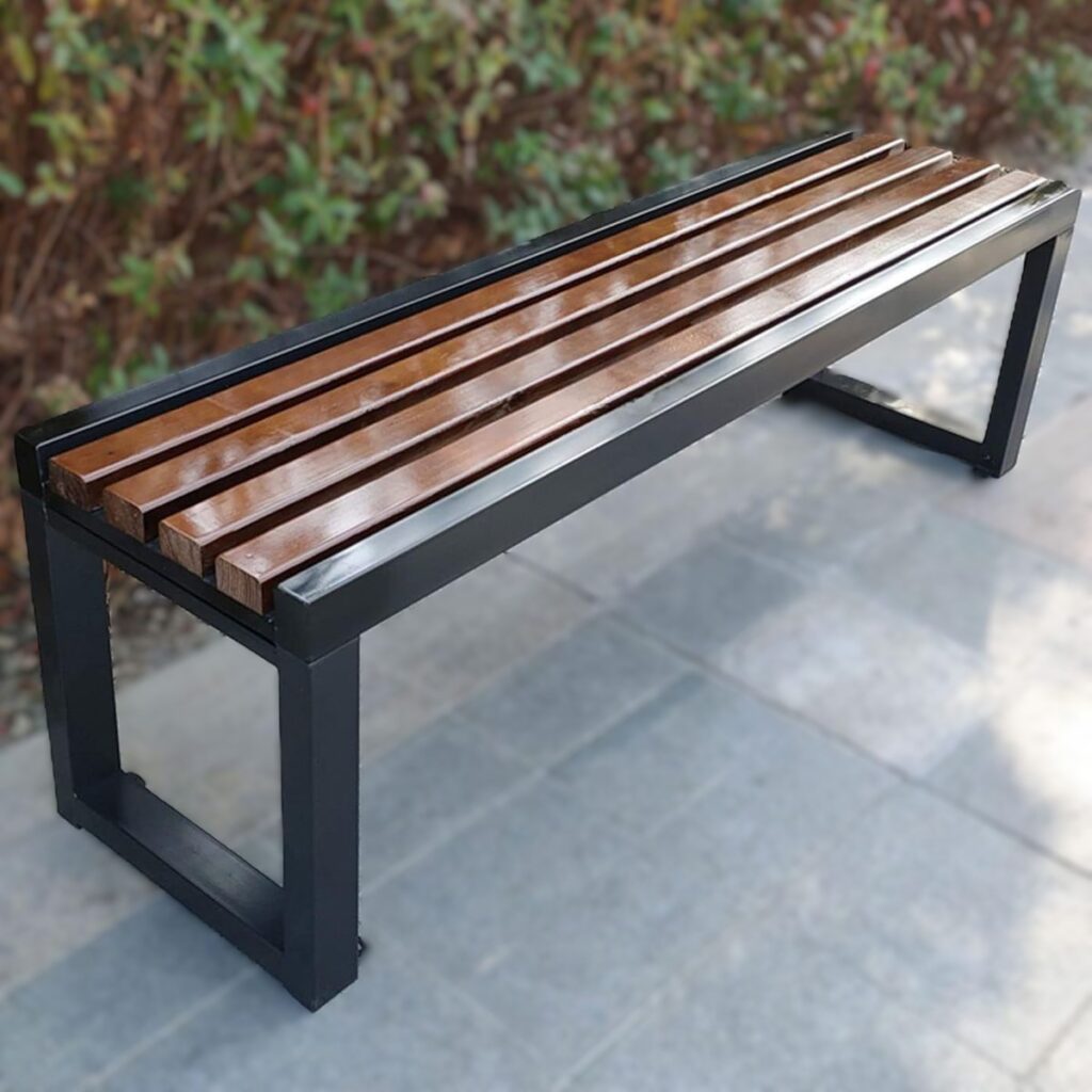 Durable black slatted metal backless bench with floor-mounting legs for commercial waiting rooms, hospitals, and outdoor public spaces.