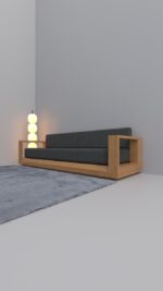 Modern executive lounge sofa with a thick solid oak frame and charcoal grey cushions shown from a perspective angle.