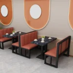 Modern industrial cafe sofa with a black electrostatically-coated steel frame, grey upholstered cushions, and a reinforced minimalist metal chassis for restaurant seating.