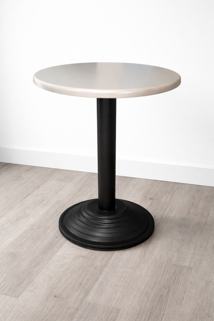 Round café table with light-colored top and black pedestal base for restaurant use