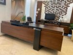 "Handcrafted executive office desk made of natural solid wood, featuring a luxury walnut finish, thick desktop, and modern architectural design with integrated side cabinet."