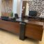 "Handcrafted executive office desk made of natural solid wood, featuring a luxury walnut finish, thick desktop, and modern architectural design with integrated side cabinet."